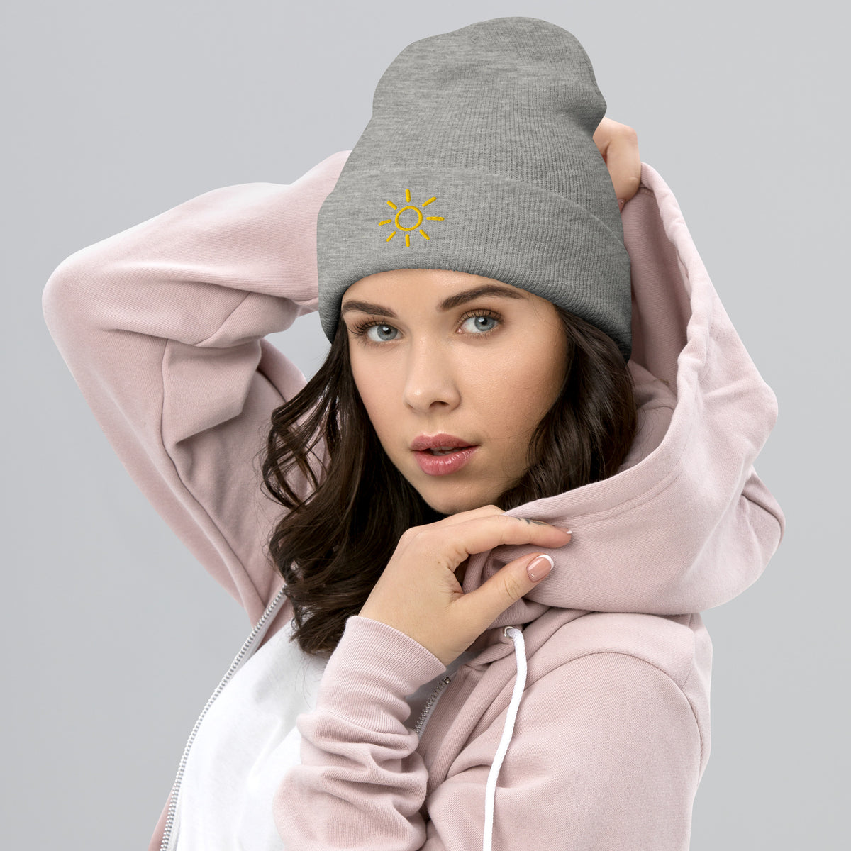 Female model wearing the light grey Sun embroidered toque by Klemm & Co., featuring the minimalist sun design in gold thread.
