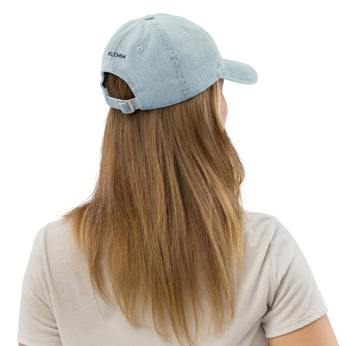 Female model wearing the light blue denim Rock Your Soul baseball hat by Klemm & Co., back view showing KLEMM embroidered in navy thread.