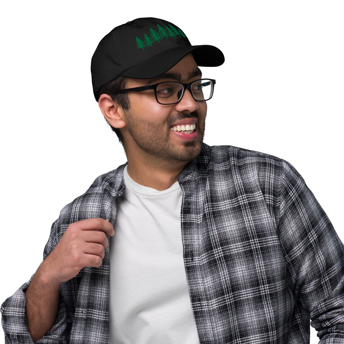 Male model wearing the black Into the Pines baseball hat by Klemm & Co., angled left to show the embroidered pine tree design in green thread.