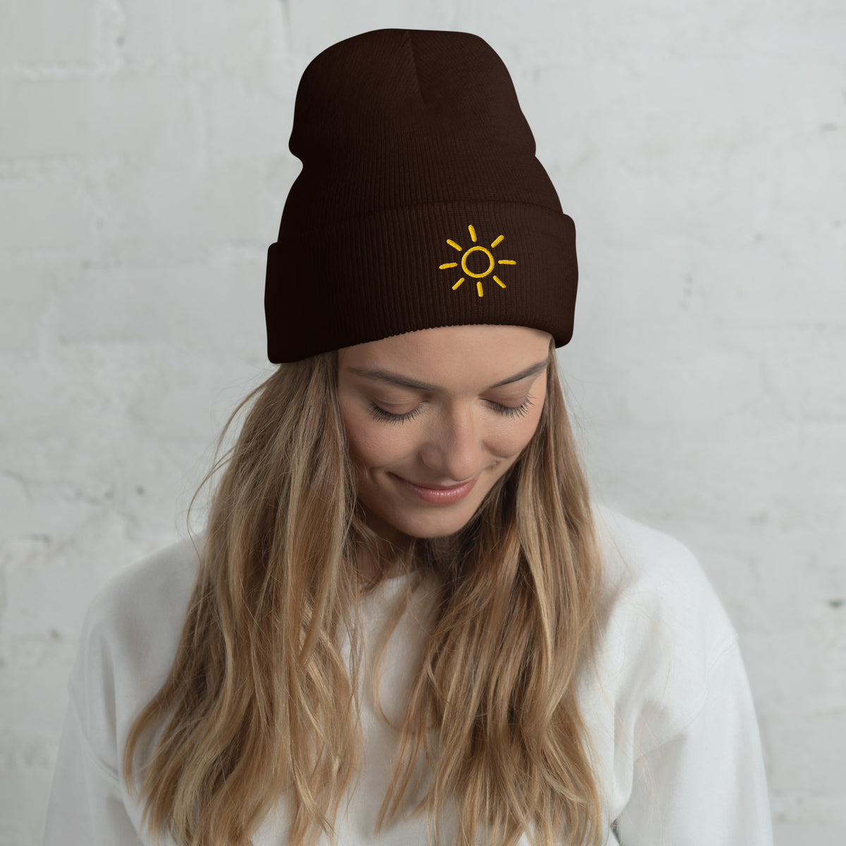 Female model wearing the brown Sun embroidered toque by Klemm & Co., featuring the minimalist sun design in gold thread.
