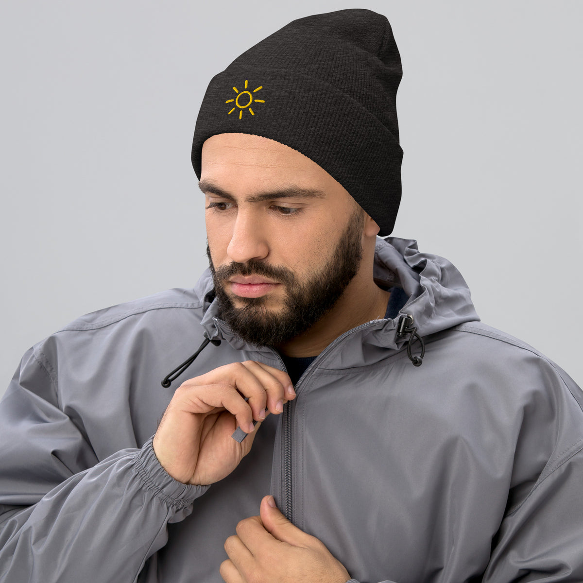 Male model wearing the dark grey Sun embroidered toque by Klemm & Co., featuring the minimalist sun design in gold thread.