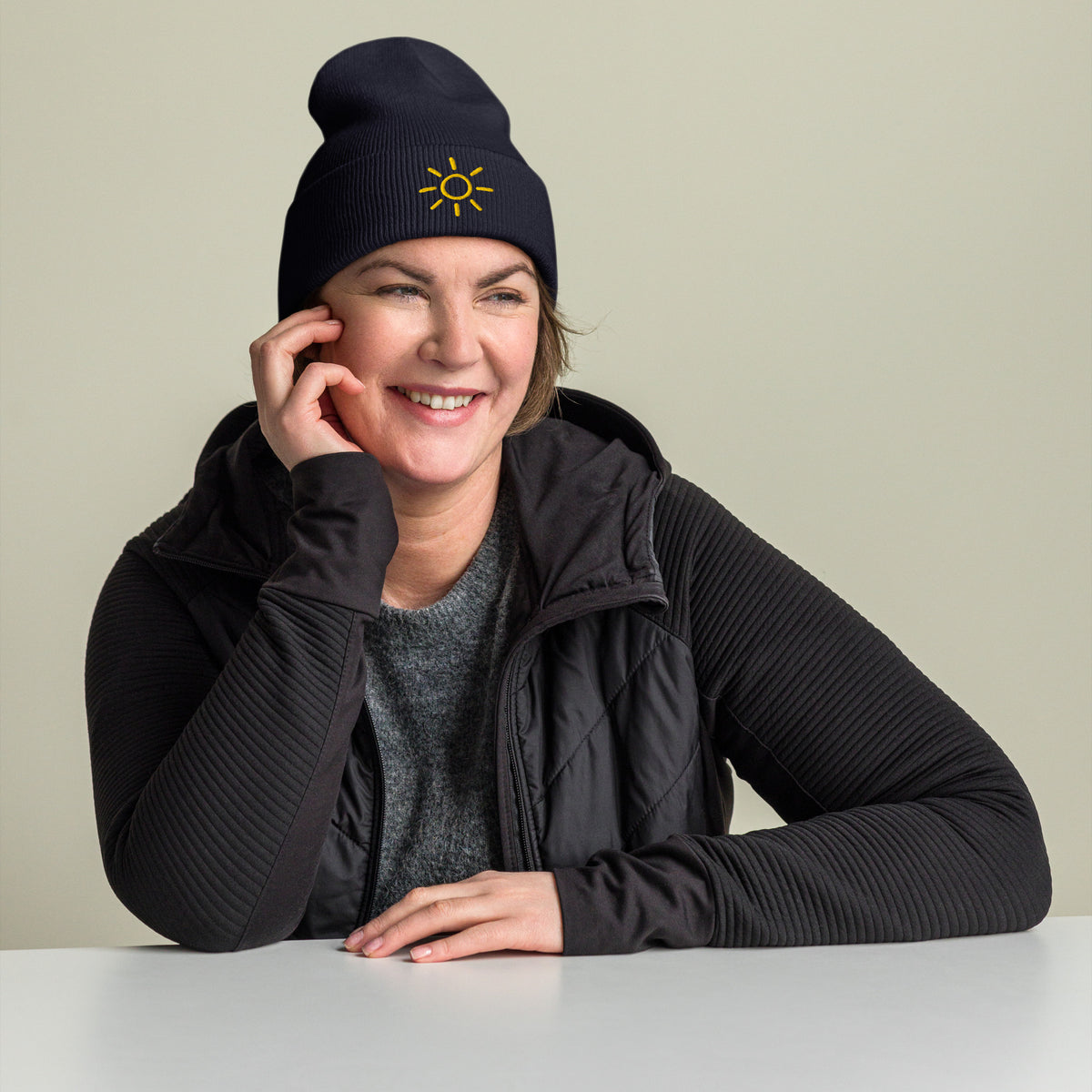 Female model wearing the navy Sun embroidered toque by Klemm & Co., featuring the minimalist sun design in gold thread.