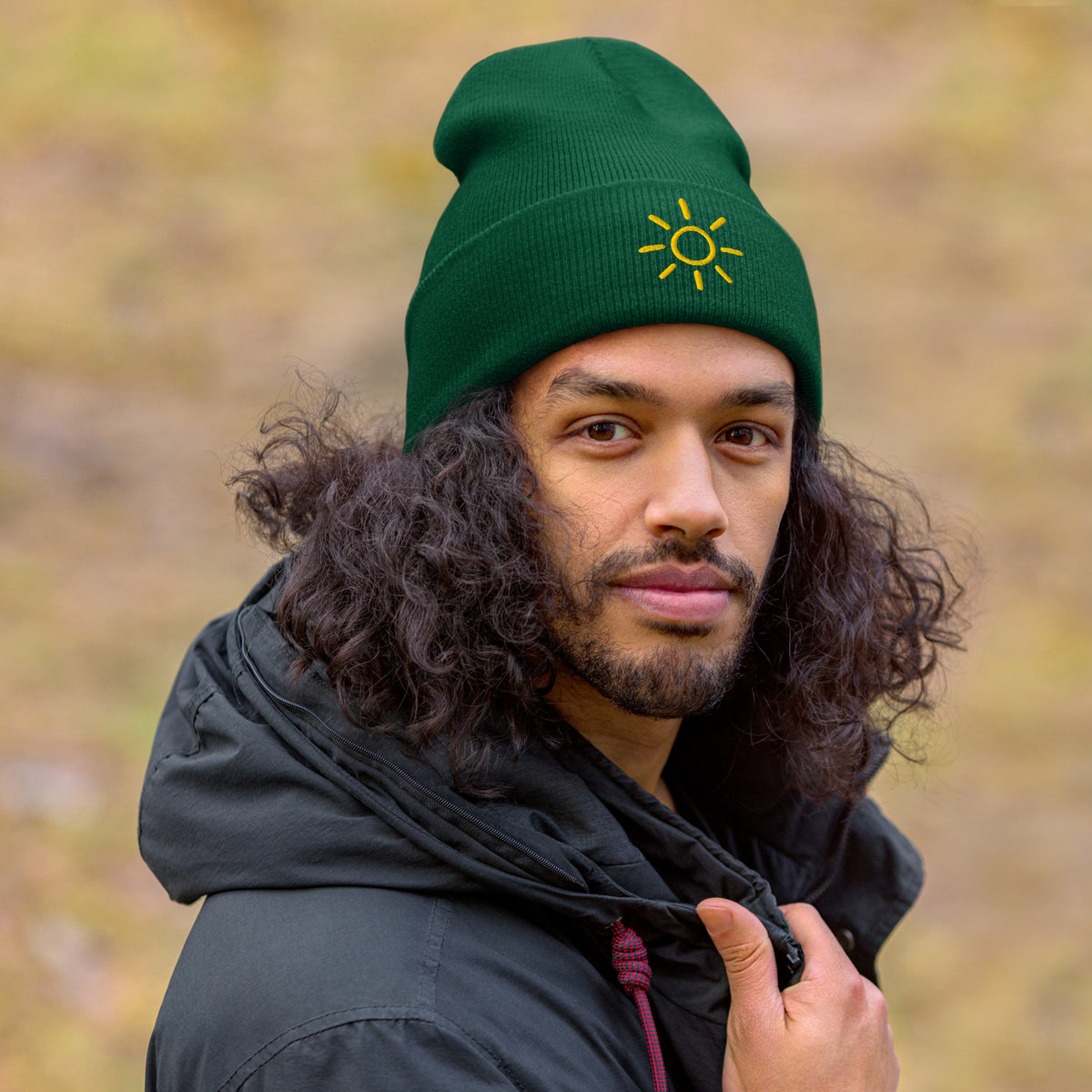 Male model wearing the green Sun embroidered toque by Klemm & Co., featuring the minimalist sun design in gold thread.
