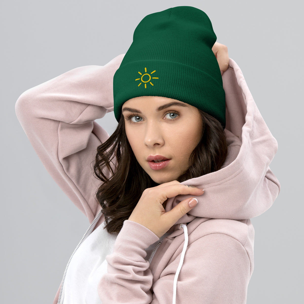 Female model wearing the green Sun embroidered toque by Klemm & Co., featuring the minimalist sun design in gold thread.