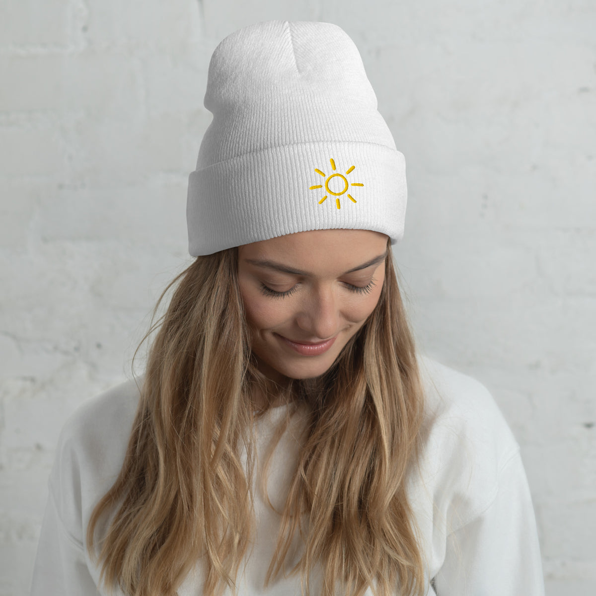 Female model wearing the white Sun embroidered toque by Klemm & Co., featuring the minimalist sun design in gold thread.