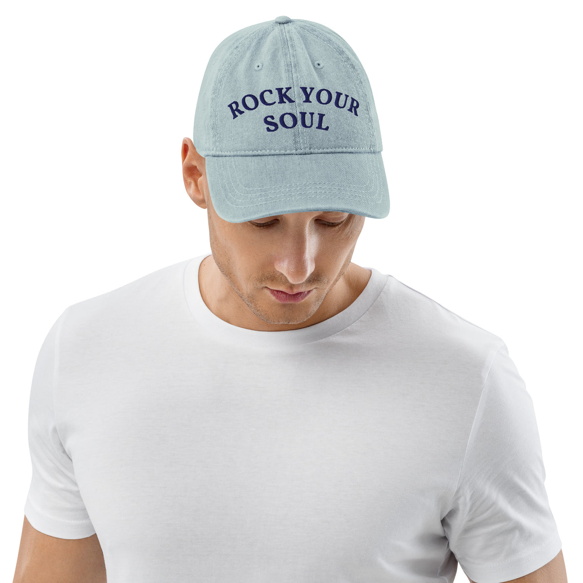 Male model wearing the light blue denim Rock Your Soul baseball hat by Klemm & Co., front view showing ROCK YOUR SOUL embroidered in navy thread.