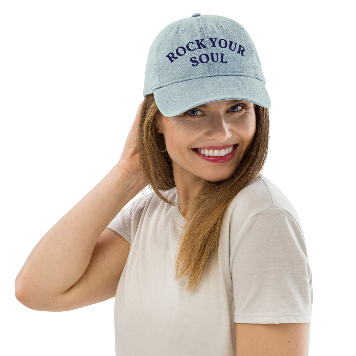 Female model wearing the light blue denim Rock Your Soul baseball hat by Klemm & Co., front-left view showing ROCK YOUR SOUL embroidered in navy thread.