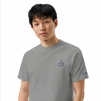 Male model wearing the grey Poured for This coffee T-shirt by Klemm & Co., front view showing the coffee cup design embroidered in navy thread.