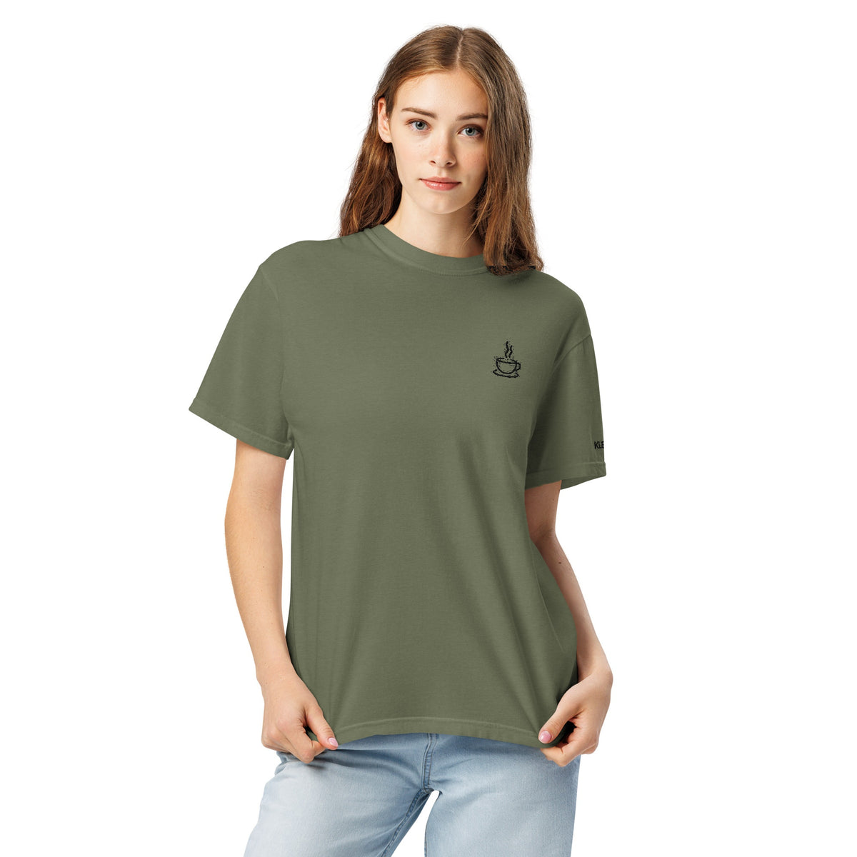 Female model wearing the moss Poured for This coffee T-shirt by Klemm & Co., front view showing the coffee cup design embroidered in black thread.