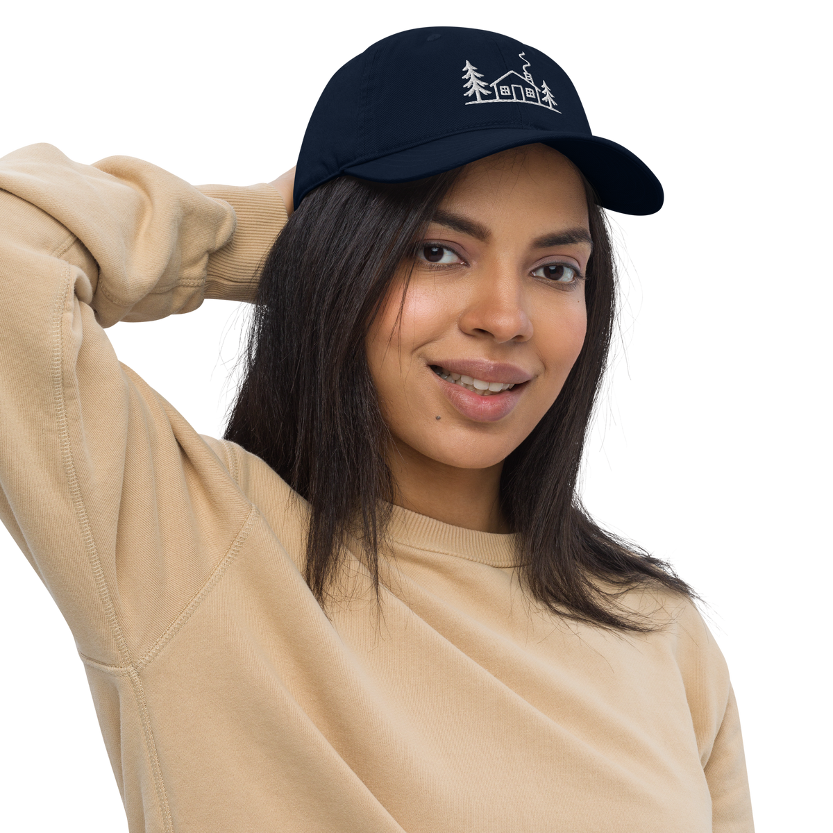 Female model wearing the navy Meet Me at the Cabin baseball hat by Klemm & Co., featuring the white embroidered cabin and pine tree design.