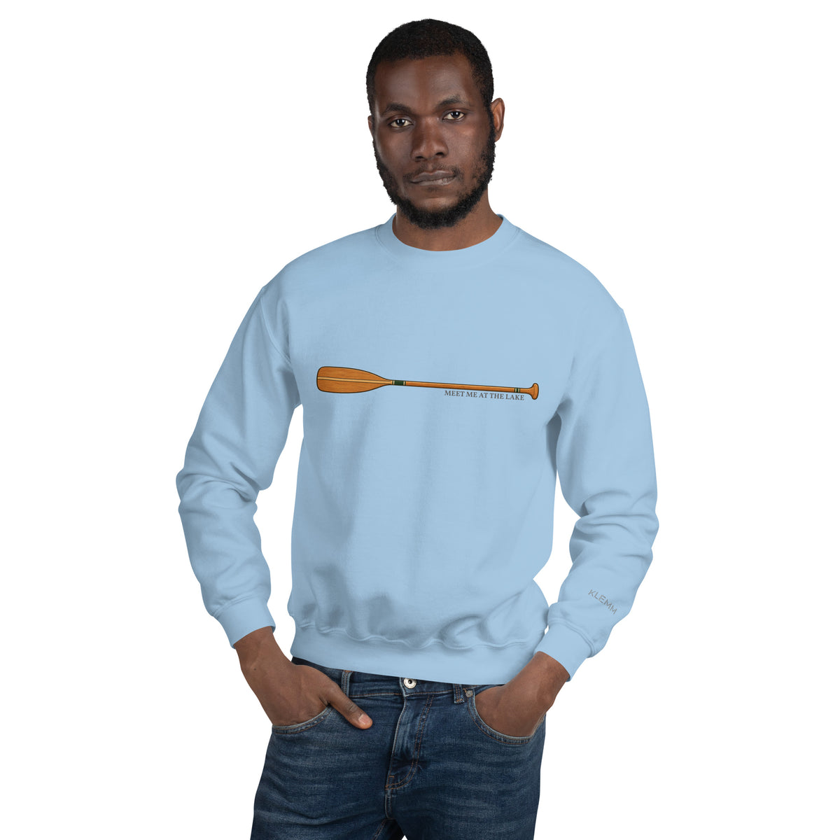 Male model wearing the light blue Meet Me at the Lake crewneck sweatshirt by Klemm & Co., front view showing the printed paddle design.