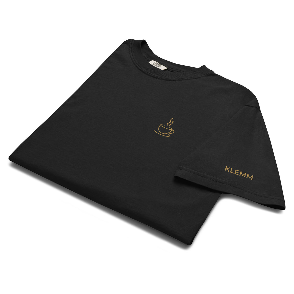 Folded black Poured for This coffee T-shirt by Klemm & Co., showing the coffee cup design and KLEMM embroidered in gold thread on the sleeve.
