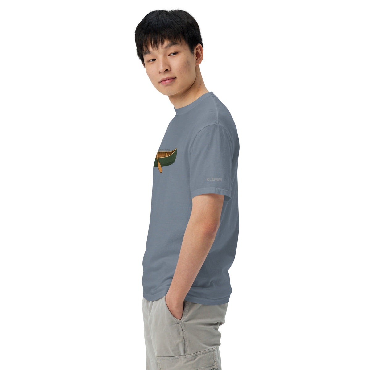 Male model wearing the blue jean Meet Me at the Dock graphic T-shirt by Klemm & Co., side view showing the printed KLEMM sleeve branding.