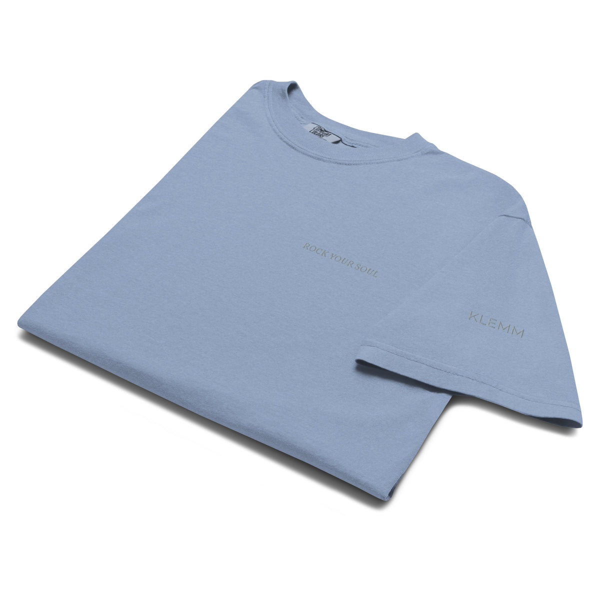 Folded washed denim Rock Your Soul T-shirt by Klemm & Co., showing ROCK YOUR SOUL and KLEMM sleeve branding embroidered in grey thread.