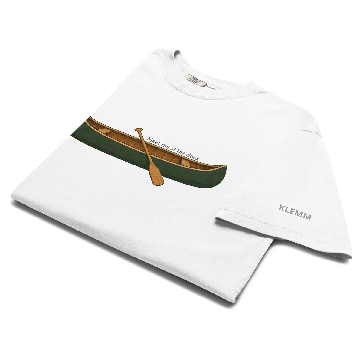 Folded white Meet Me at the Dock graphic T-shirt by Klemm & Co., showing the printed KLEMM sleeve branding.