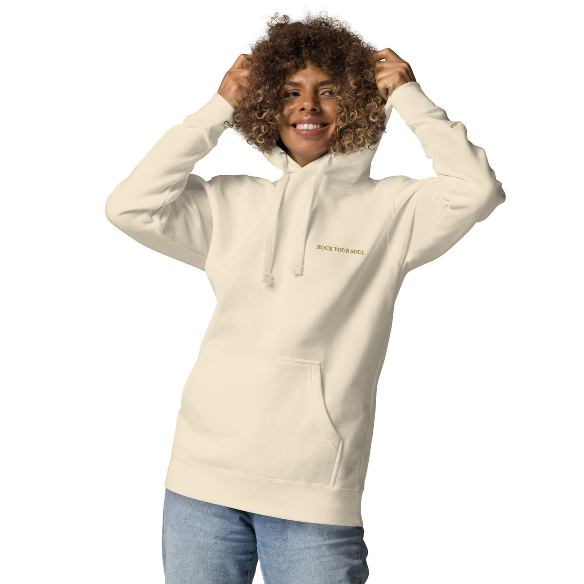Female model wearing the bone Rock Your Soul hoodie by Klemm & Co., front view lifting the hood, showing ROCK YOUR SOUL embroidered in gold thread.