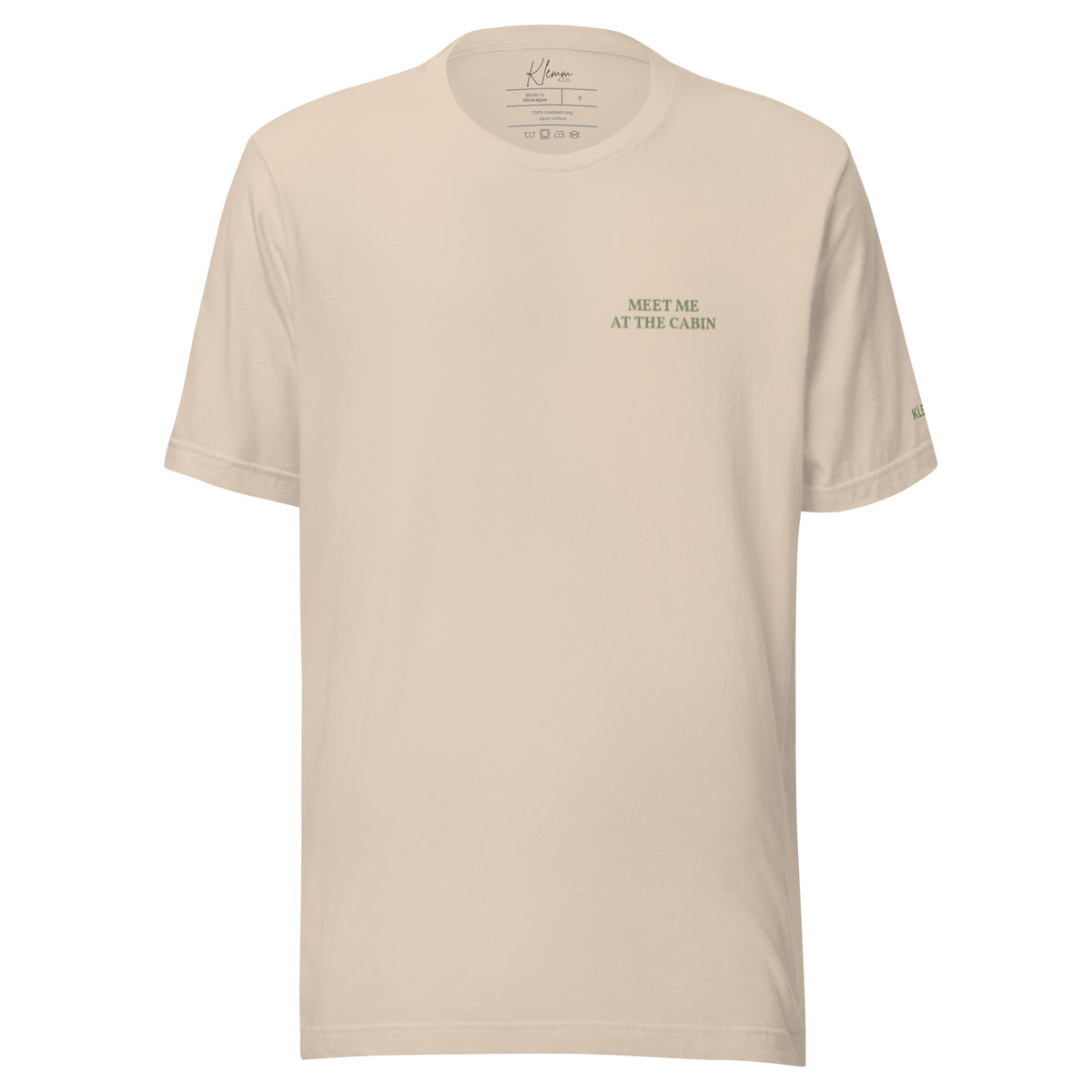 Soft cream Meet Me at the Cabin graphic T-shirt by Klemm & Co., front view with subtle green chest text.